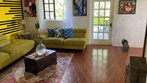Un salon avec un canapé vert, un tapis à motifs et une table basse.