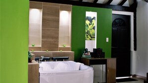 Une salle de bain moderne avec une grande baignoire, des murs verts et un plafond en bois.