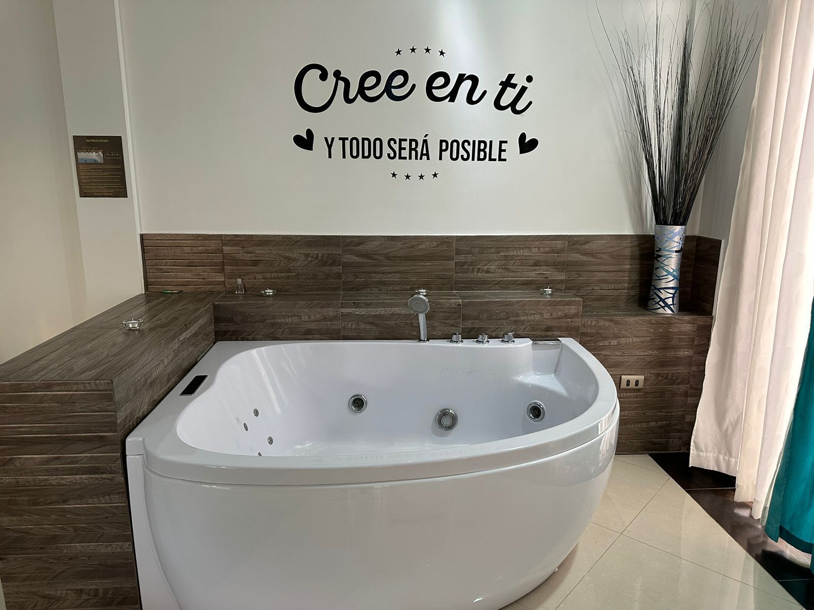 Une salle de bain moderne avec une baignoire sur pieds, un lambris en bois et une citation inspirante peinte sur le mur.