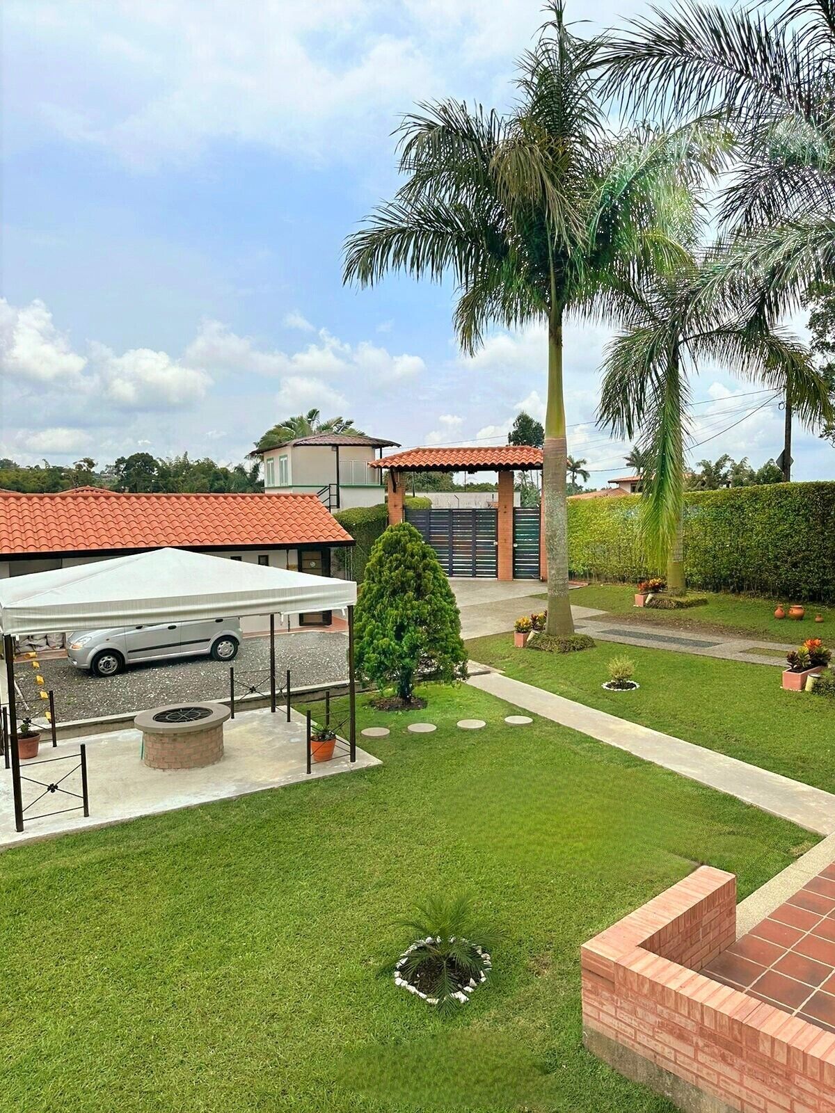 Una propiedad residencial con patio cubierto, un jardín pequeño y garaje.