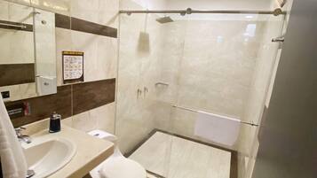 A modern bathroom with a glass-enclosed shower, a sink, and a toilet.