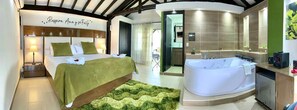 A bedroom with a bed, bedside table, and a green area rug.