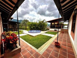 Un patio con jacuzzi, una hamaca y vistas a las montañas.