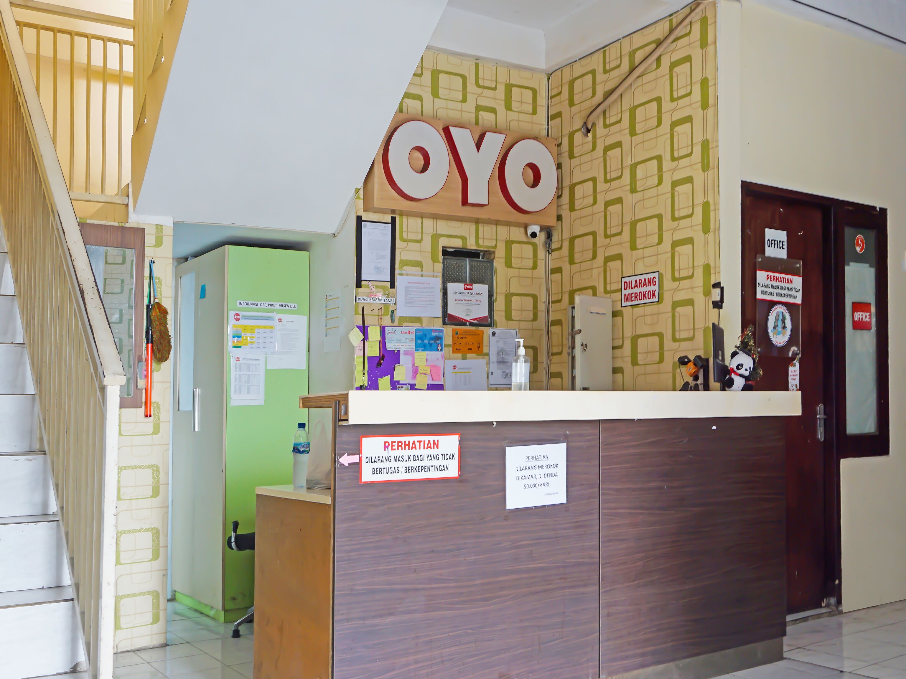 A reception desk with a sign that reads 'OYO' and a sign indicating the office is located on the right.
