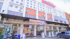 A hotel with a prominent 'OYO' sign, a 'UP CASAR HOTEL' sign, and a 'CHANNEL PREMIUM Coffee' sign. - Capital O 854 Ub Caisar Hotel (Banda Aceh)