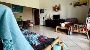 A living room with a sofa, a television, a dining area with chairs, and a table. - N084 - Numana, villa with garden and pool (Numana)