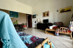 A living room with a sofa, a television, a dining area with chairs, and a table. - N084 - Numana, villa with garden and pool (Numana)