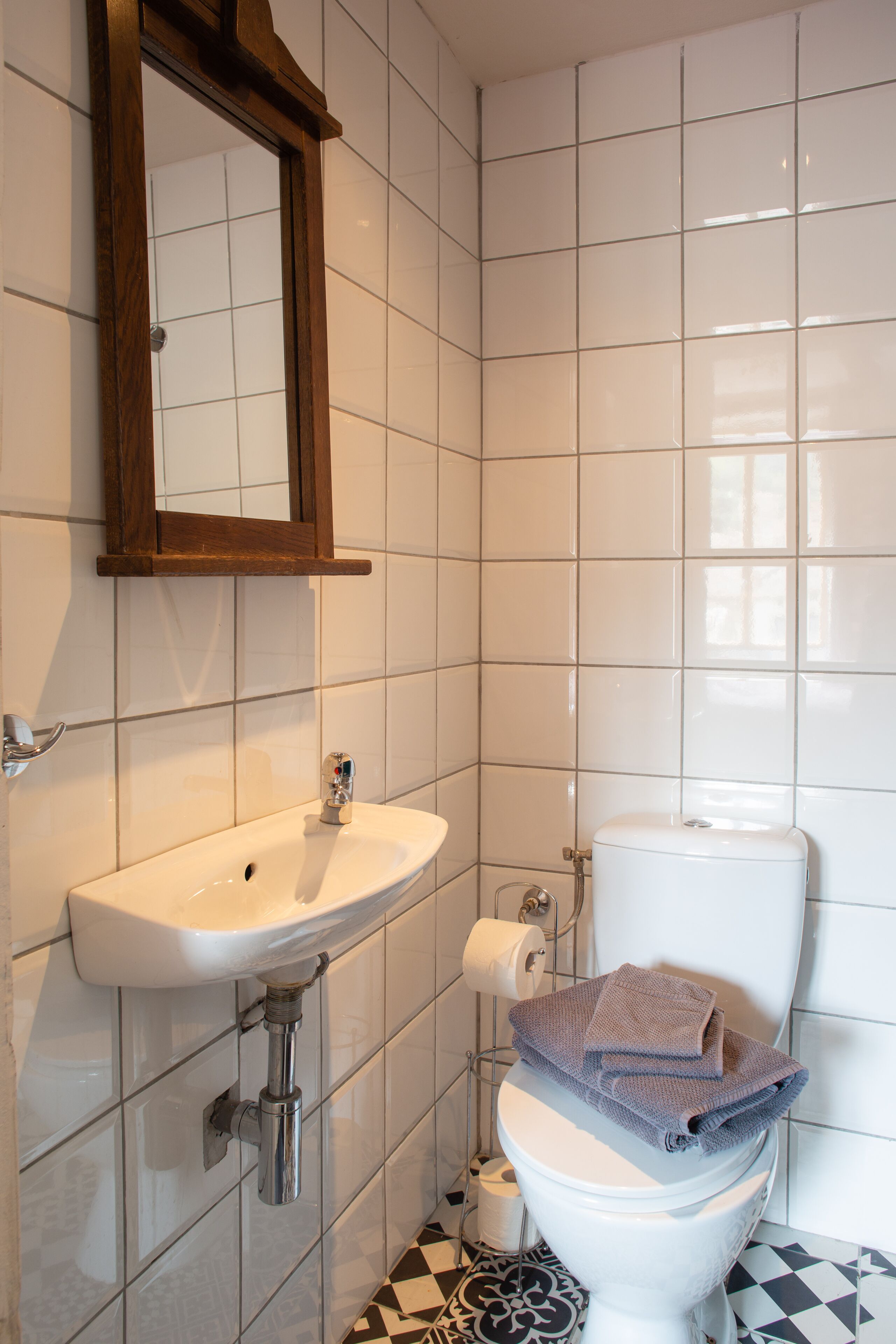 Un baño con un lavabo blanco, un espejo y un inodoro.