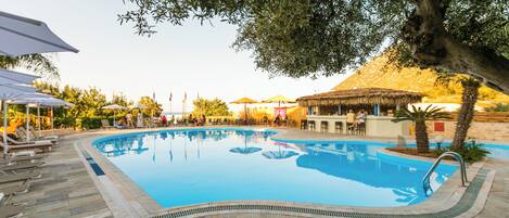 Een buitenzwembad en ligstoelen