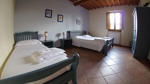 Un dormitorio con dos camas, una ventana con luz natural y un radiador.