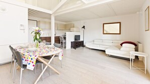 A modern living space with a dining area, kitchen, and seating area. - GuestHost - NEW! Exclusive Loft with balcony & garden! (Milano)