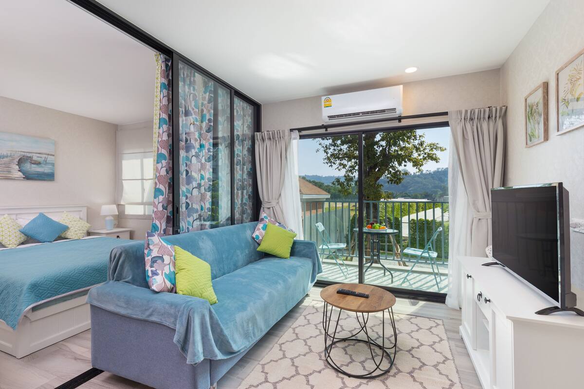 Une chambre moderne avec un canapé, une télévision et un balcon offrant une vue agréable.