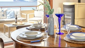 A dining table set with plates, glasses, and a candle, overlooking a scenic view.