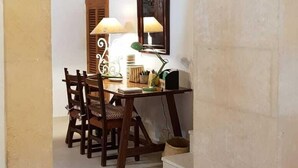 An arched doorway leading to a dining area with a table, chairs, and a lamp.