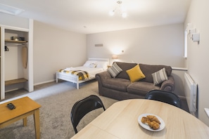 Cozy retreat with a single bed, sofa, and bench, perfect for a comfortable stay.