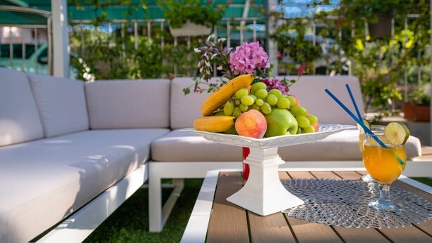 A white outdoor seating area with a table set for a meal. - Apartments Lovric - Apt 2 (Pula)