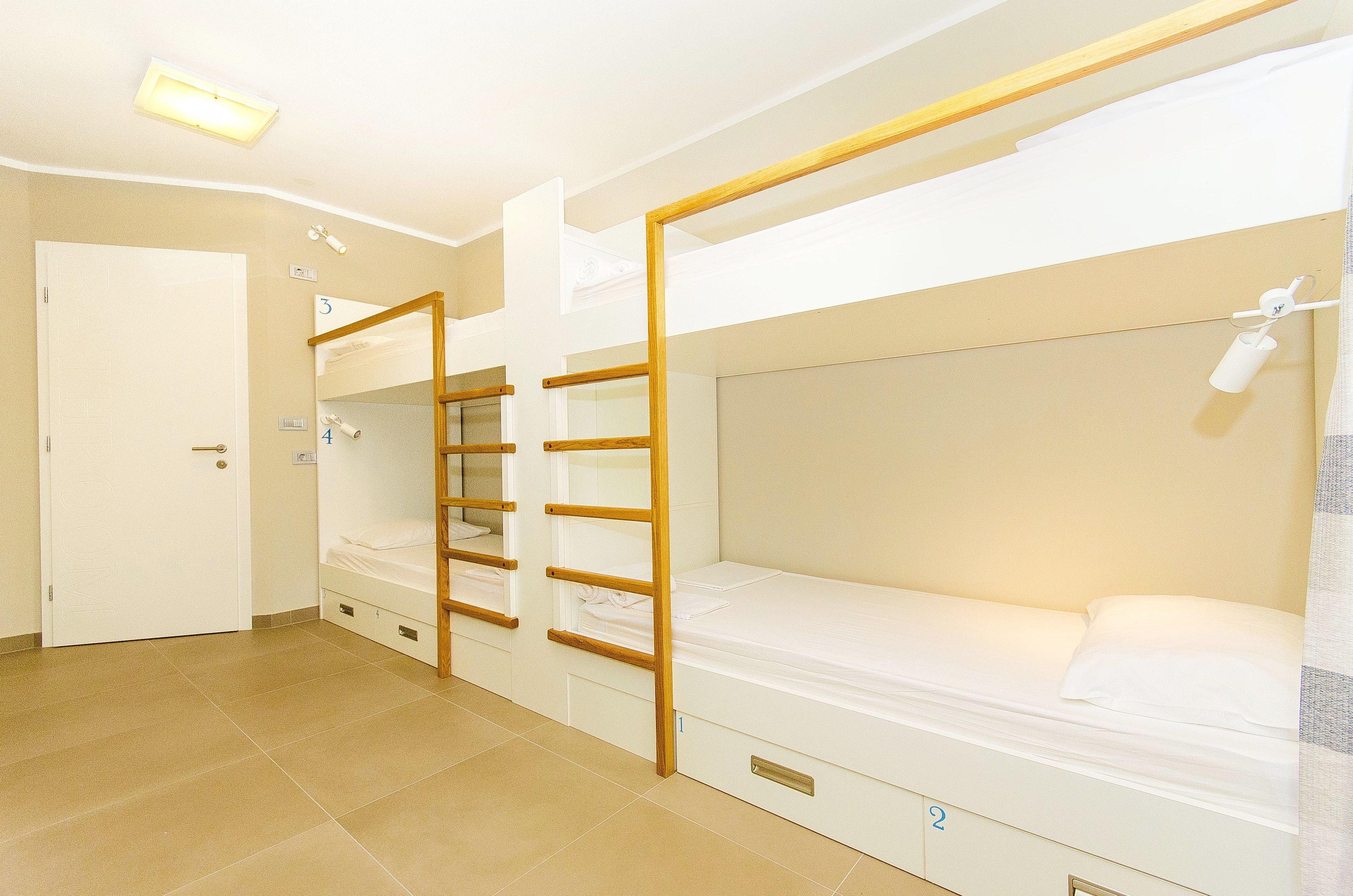 A room with bunk beds, a door, and a ceiling light.