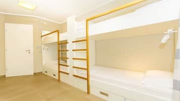 A room with bunk beds, a door, and a ceiling light.