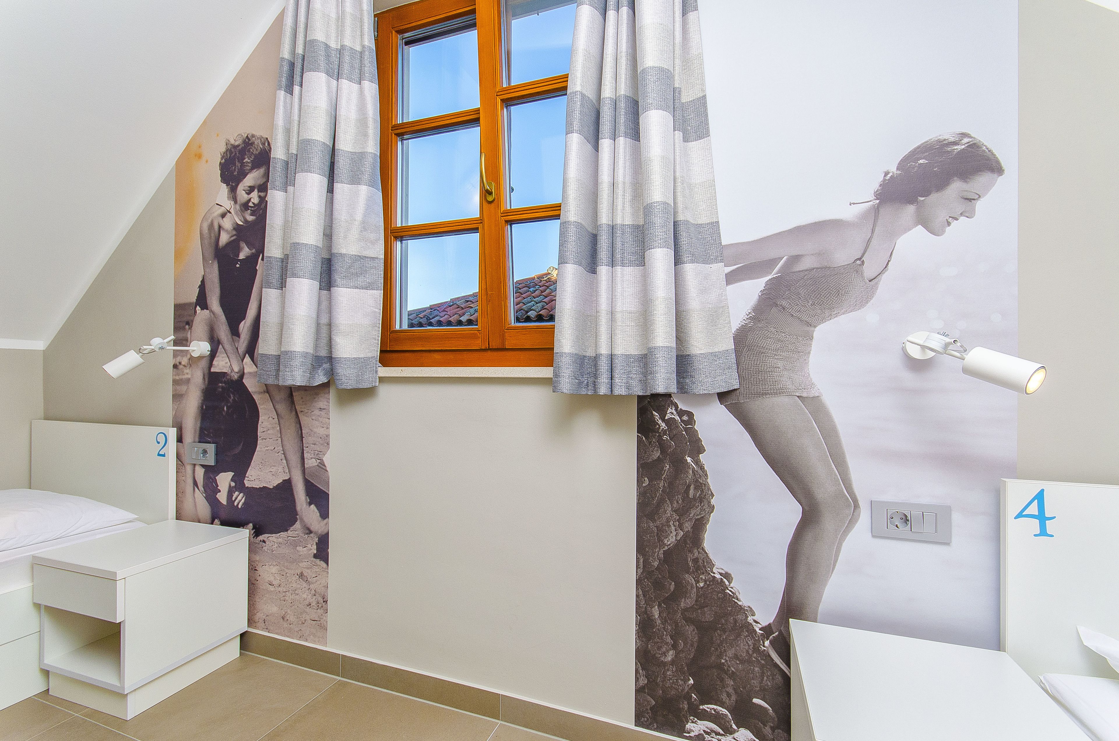 A bathroom with a window, a shower, and a toilet.