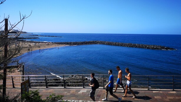 Un paseo marítimo con vistas al océano y rompeolas rocosas.