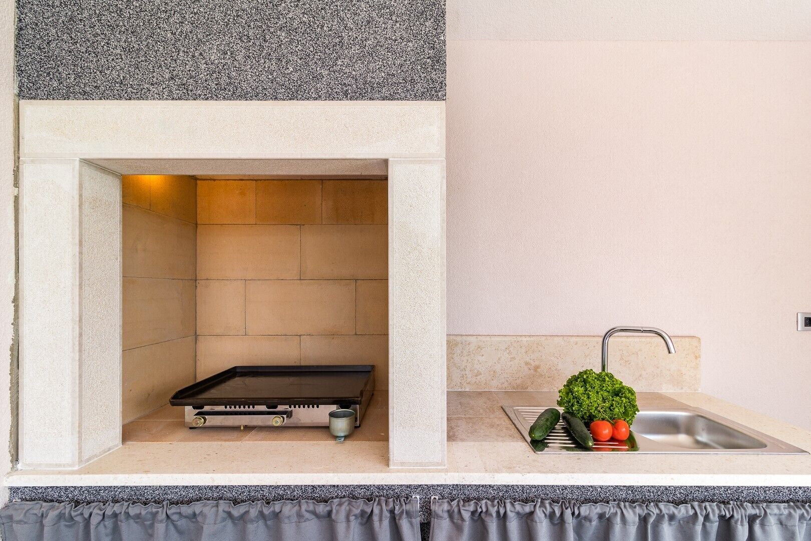 A compact kitchenette with a built-in oven, a sink, and a small countertop.