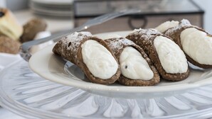 Un plato con cannoli sobre una superficie de vidrio.