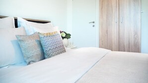 A bedroom with a bed, pillows, a nightstand, and a wardrobe. - Villa Lotus (Pag)