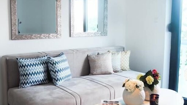 A modern living room with a sofa, a coffee table, and decorative items. - Villa Lotus (Pag)