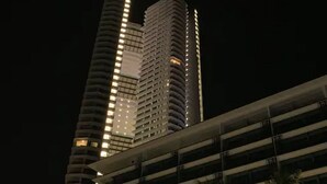 Een hotel met een opvallend 'Google Residence' bord, een waterpartij met fonteinen, en hoge gebouwen op de achtergrond.