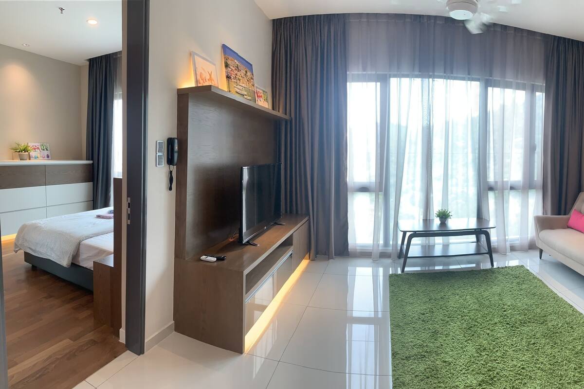 Uma sala de estar moderna com um sofá, uma TV e um espaço de jantar.
