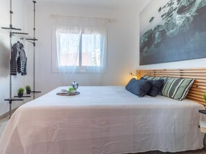 1 dormitorio y tabla de planchar con plancha