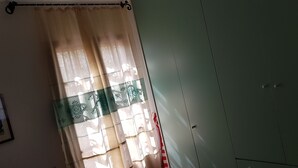 A room with a green wardrobe, a window with sheer curtains, and a visible door handle. - Single villa from Titti and Carlo a stone's throw from the sea (Perd'e Sali)
