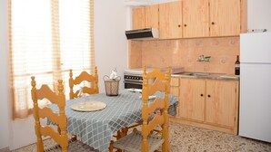 Une cuisine avec des meubles de rangement en bois, une cuisinière et un évier.