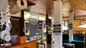 A reception area with a wooden counter, a reception desk, and a sign that reads "RECEPTION". - Bella Athena Garden (El Nido)