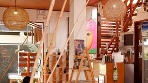 A cozy interior with a wooden staircase, wicker furniture, and a variety of decorative items. - Bella Athena Garden (El Nido)