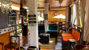 A cozy interior with wooden flooring, a reception area, and seating arrangements. - Bella Athena Garden (El Nido)