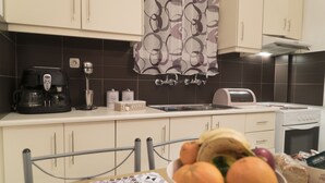 A kitchen with a coffee maker, toaster, and a bowl of fruit on the counter. - Sofia's Residence by Estia (Heraklion)