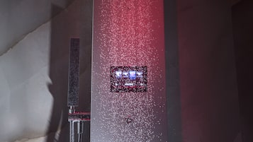 Una ducha moderna con un chorro de agua vertical y un panel de control.
