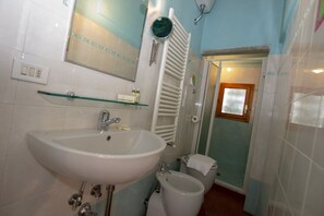 Kylpyhuone, jossa on pesuallas, peili, pyyheteline ja wc.