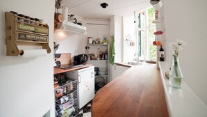 Una cocina con mostrador de madera, una cafetera y una variedad de utensilios y electrodomésticos.