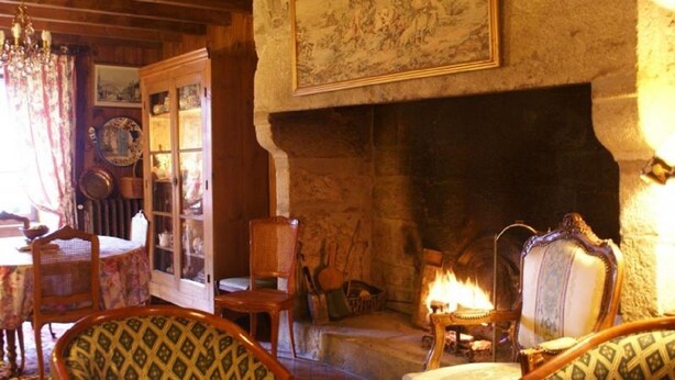 A cozy room with a fireplace, wooden furniture, and a bookshelf.