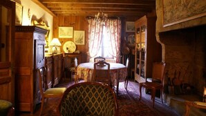 A traditional dining room with wooden furniture, a chandelier, and a fireplace.
