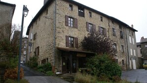 A stone building with multiple windows and a small porch.