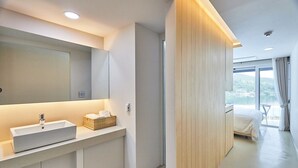 Un bagno moderno con uno specchio grande, un lavandino bianco e una parete rivestita in legno.