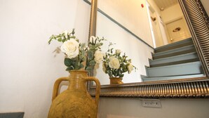 A staircase with a mirror reflecting the room. - Kastoria Butik Pansiyon (Ayvalik)