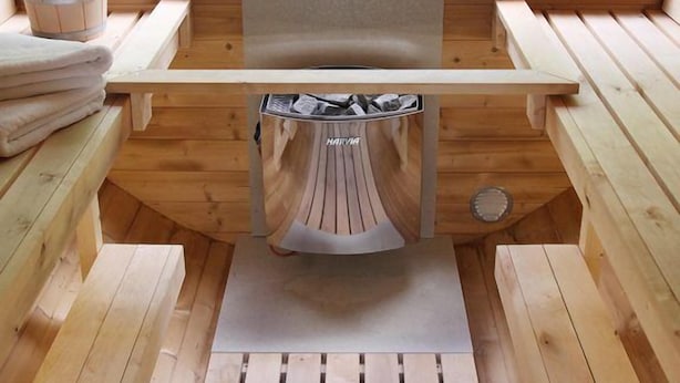 A wooden sauna with benches and a bench seat, a towel rack, and a window overlooking greenery. - Villa Thormarcon (Malchow)