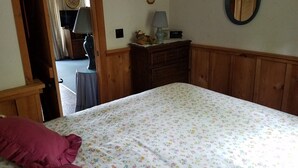 A bedroom with a bed, a dresser, a mirror, and a door leading to another room. - Treehouse type cottage in private location - Pet friendly! (Franklin)