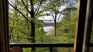 A wooden deck with a bench overlooking a lake surrounded by trees. - Treehouse type cottage in private location - Pet friendly! (Franklin)