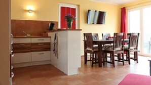 A compact kitchen with a dining area. - Ferienhaus Thormarcon (Goehren-Lebbin)