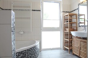 A modern bathroom with a bathtub, a toilet, and a sink.